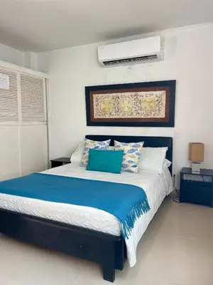 a bedroom with a bed with blue and white pillows at Cielo mar 202 frente a hotel Las Américas in Cartagena de Indias
