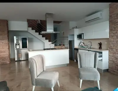 a kitchen with two chairs and a counter and a staircase at Resort frente al mar in Juan de Acosta