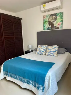 a bedroom with a bed with a blue blanket at Cielo Mar 102 frente a Hotel Las Américas in Cartagena de Indias