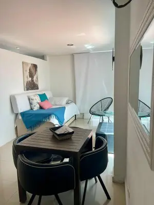 a room with a bed and a table with chairs at Cielo Mar 102 frente a Hotel Las Américas in Cartagena de Indias