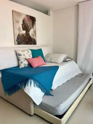 a bed with colorful pillows on it in a room at Cielo Mar 102 frente a Hotel Las Américas in Cartagena de Indias