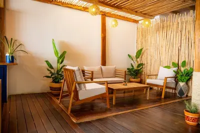a porch with a couch and chairs and plants at Mar Barú Beach House in Playa Blanca