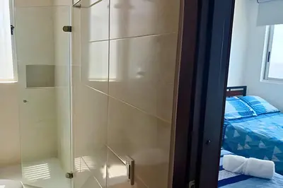 a shower with a glass door next to a bed at Increíble vista al mar en el corazón de Bocagrande in Cartagena de Indias