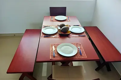 a wooden table with white plates and forks and knives at Increíble vista al mar en el corazón de Bocagrande in Cartagena de Indias