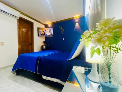a blue bedroom with a bed and a vase of flowers at Casa de lujo en Condominio Privado por Habitaciones in Cartagena de Indias