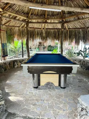 a pool table sitting under a thatch roof at Villa del Atardecer Caribeño - JhonLimar in Bocachica