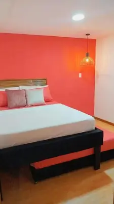 a bedroom with a large bed with a red wall at Hb-m8 House With 8 Bedrooms, Pool And Near The Sea in Cartagena de Indias