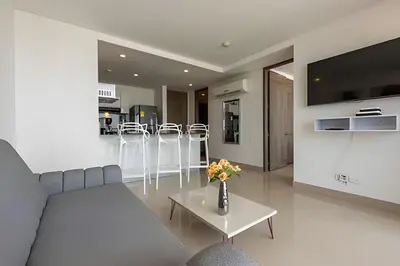 a living room with a couch and a table with flowers at 1004 Morros City - Spectacular 1 Bedroom Condo in Cartagena de Indias