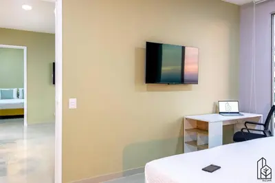 a room with a bed and a television on the wall at Bizsar Mar 4 Piscinas Acceso privado playa BBQ privado in Cartagena de Indias