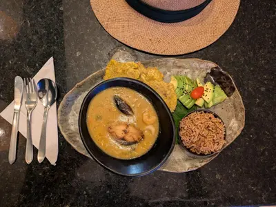 a plate of food with a bowl of soup and vegetables at Bizsar Mar 4 Piscinas Acceso privado playa BBQ privado in Cartagena de Indias