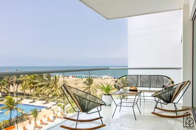 a balcony with chairs and a table and a view of the beach at Bizsar Mar 4 Piscinas Acceso privado playa BBQ privado in Cartagena de Indias