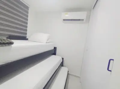 a white bedroom with a bed and a shower at A 20 min CC Vista vista con patio fácil acceso in Barranquilla