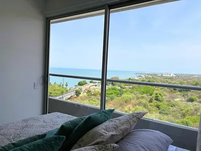 a bedroom with a bed and a large window at Apartasuite x4 Playa Piscina Jacuzzi Zona Decameron Santa Marta in Santa Marta