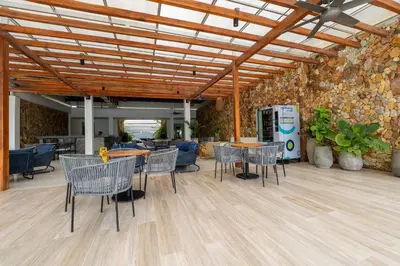 a room with tables and chairs and a stone wall at Ubicación soñada en Cartagena | Apartamento premium en Baia Kristal in Cartagena de Indias