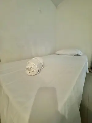 a white bed with a white sheet on it at Playa Virginia Beach House Privada in San Silvestre