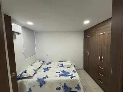 a small bedroom with a bed with blue flowers on it at Hermoso Apartamento Cartagena cerca al Mar in Cartagena de Indias