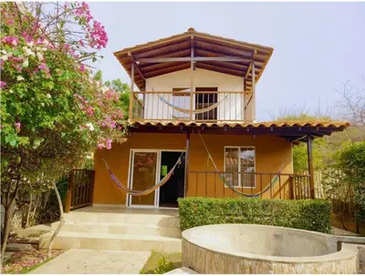 a yellow house with a balcony and a tree at Tu paraíso frente al mar te espera en Santa Verónica in Tubará