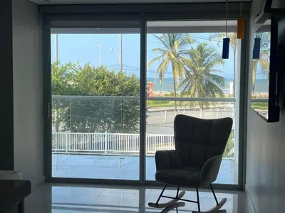 a chair in front of a window with a view at ocean drive magnifica vista y piscina in Cartagena de Indias