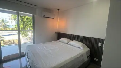 a bedroom with a bed and a large window at ocean drive magnifica vista y piscina in Cartagena de Indias