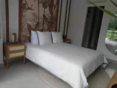 a bed with white sheets and pillows in a bedroom at Apto de Ensueño en aguas cristalinas Baía Kristal in Cartagena de Indias