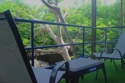 a balcony with a table and chairs and a tree at MANGO BREEZE Casa de Playa en Tierrabomba in Tierra Bomba