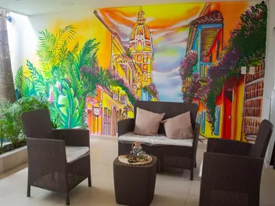 a room with a couch and chairs in front of a mural at Casa gimani Betts in Cartagena de Indias