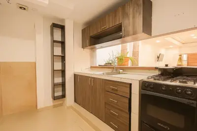 a kitchen with wooden cabinets and a stove top oven at Casa gimani Betts in Cartagena de Indias