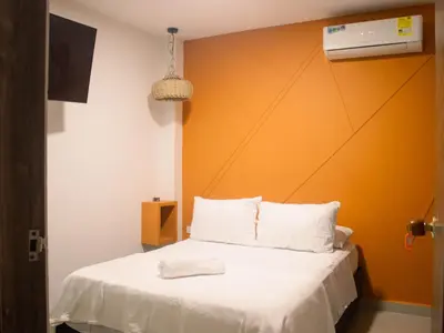 a bedroom with a bed with an orange wall at Casa gimani Betts in Cartagena de Indias