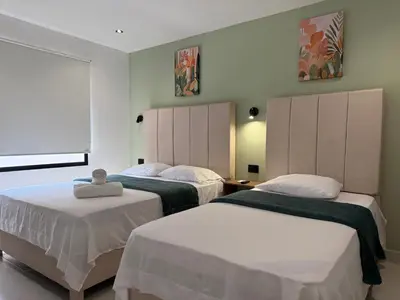 a bedroom with two beds and a window at Arcadia Hotel in Cartagena de Indias