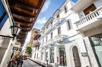 a group of people walking down a street with buildings at Historic Getaway with Breakfast in Cartagena de Indias