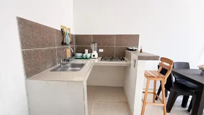 a small kitchen with a sink and a stove at Cabaña Datalu 1 in Coveñas
