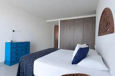 a bedroom with a bed and a blue dresser at Lujoso Apto de 2 Hab en Piso 14 Morros City in Cartagena de Indias