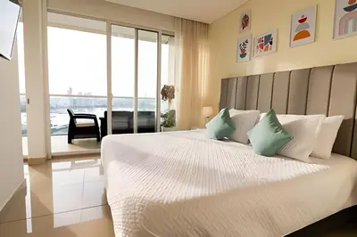 a bedroom with a bed with a view of the ocean at Lujoso apto de 1 hab en piso 15 Edificio H2 in Cartagena de Indias