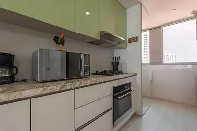 a kitchen with white cabinets and a microwave oven at Lujoso Apto de 2 habitaciones en piso 15 in Cartagena de Indias