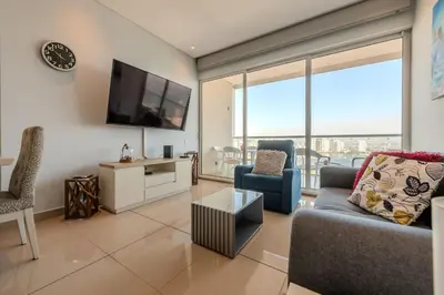 a living room with a tv and a couch and chairs at Condominio H2-Luxurious 2 BR / 16th F - Bocagrande in Cartagena de Indias