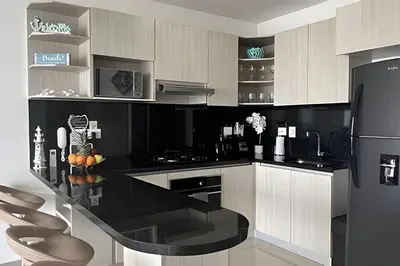 a black and white kitchen with a black refrigerator at Hermoso Apto de 1 hab con Vista al Mar - Piso 16! in Cartagena de Indias