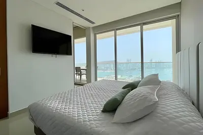 a bedroom with a bed with pillows and a flat screen tv at Lujoso Apto de 1 Habitación en Piso 17 -H2 Hyatt in Cartagena de Indias