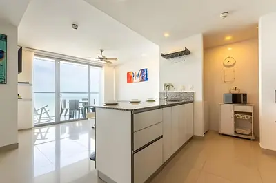 a kitchen with white cabinets and a view of the ocean at 1702 Morros City - Espectacular Apto en Bocagrande in Cartagena de Indias