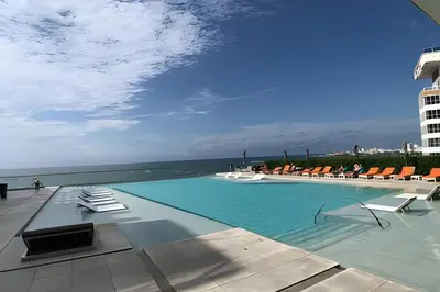 a swimming pool with chairs and a view of the ocean at 1702 Morros City - Espectacular Apto en Bocagrande in Cartagena de Indias