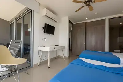 a bedroom with a blue bed and a desk at 1702 Morros City - Espectacular Apto en Bocagrande in Cartagena de Indias