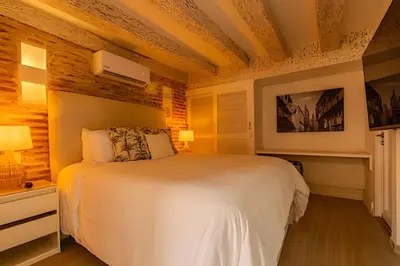 a bedroom with a white bed and wooden ceilings at Casa Bóvedas - Paraíso de 5 habitaciones in Cartagena de Indias
