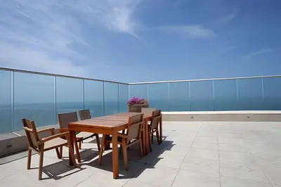 a wooden table and chairs on a balcony at 1705 Palmetto Beach -17th Floor Palmetto Beach in Cartagena de Indias