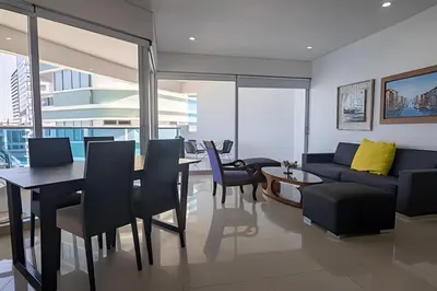 a living room with a couch and a table and chairs at Espectacular Vista Al Mar - Edificio Infinito 1802 in Cartagena de Indias