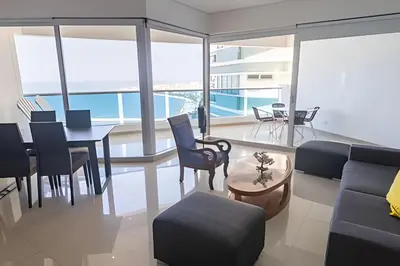 a living room with a couch and a table and chairs at Espectacular Vista Al Mar - Edificio Infinito 1802 in Cartagena de Indias