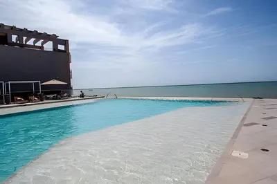 a large swimming pool next to a building with the ocean at Espectacular Vista al Mar en Morros City piso 19 in Cartagena de Indias