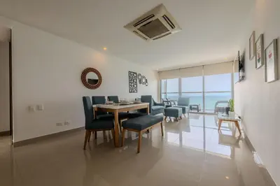 a dining room and living room with a table and chairs at Hermoso Apto 2 Hab Piso 19 en Morros City in Cartagena de Indias