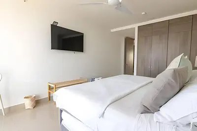 a bedroom with a bed with a tv on the wall at Lujoso Apto de 2 Hab en piso 20 - Morros City in Cartagena de Indias