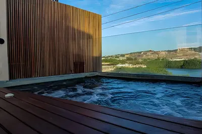 a hot tub on a deck with a view of the mountains at Espectacular Vista al Castillo de San Felipe! in Cartagena de Indias