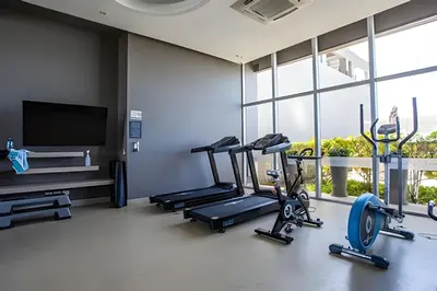 a gym with three tread machines and a flat screen tv at Apartamento Aqua 805 - Morros City in Cartagena de Indias