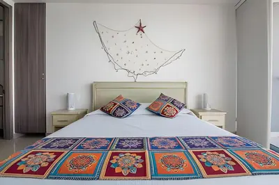 a bedroom with a large bed with colorful pillows at Morros City-Espectacular Apto Vista al Mar Piso 8 in Cartagena de Indias